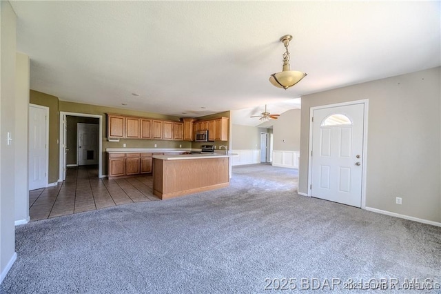 20715 Hiltner Ln, Saint Robert, MO 65584 - kitchen with carpet flooring, light countertops, stainless steel appliances, open floor plan, and a ceiling fan