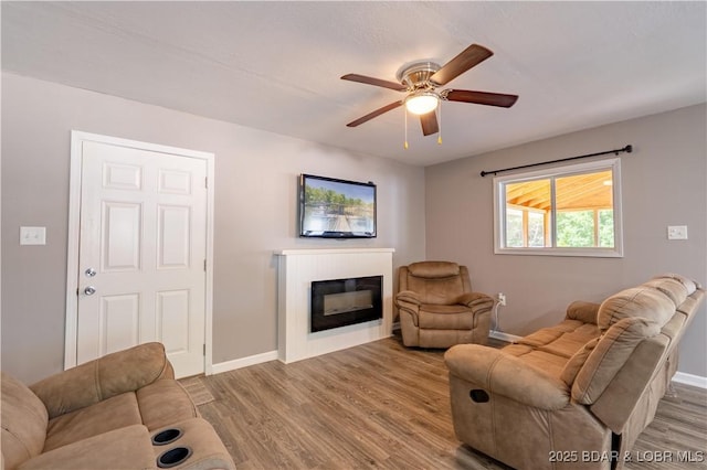 30734 Ottersway Rd, Gravois Mills, MO 65037 - living area featuring wood finished floors, a ceiling fan, and baseboards