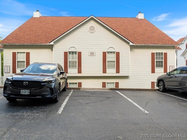 335 Charleston Dr Unit 3B, Lake Ozark, MO 65049 - view of front facade featuring a chimney, uncovered parking, and roof with shingles