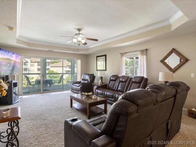 335 Charleston Dr Unit 3B, Lake Ozark, MO 65049 - carpeted living room featuring a tray ceiling, crown molding, ceiling fan, healthy amount of natural light, and a textured ceiling