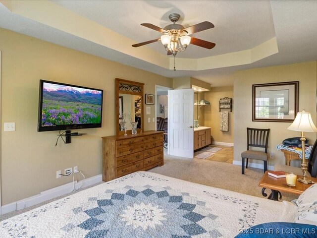 335 Charleston Dr Unit 3B, Lake Ozark, MO 65049 - bedroom featuring baseboards, a tray ceiling, light colored carpet, and ensuite bathroom