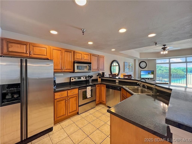 4800 Eagleview Dr Unit 6104, Osage Beach, MO 65065 - kitchen featuring appliances with stainless steel finishes, a sink, brown cabinetry, recessed lighting, and light tile patterned floors