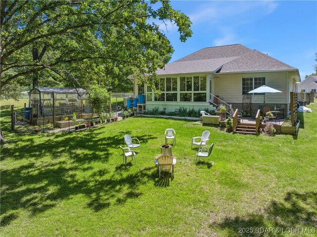 204 Wellington Ln, Laurie, MO 65037 - rear view of house featuring an exterior structure, a wooden deck, a yard, and an outbuilding