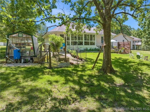 204 Wellington Ln, Laurie, MO 65037 - rear view of house featuring a lawn, a greenhouse, and an outbuilding