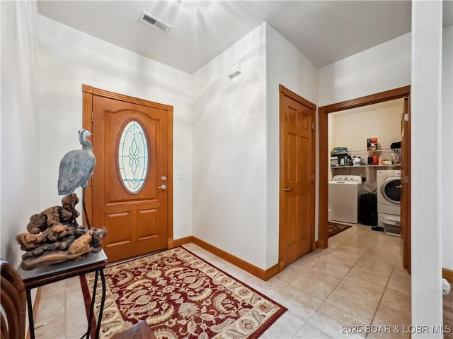204 Wellington Ln, Laurie, MO 65037 - foyer entrance with washer / clothes dryer, light tile patterned floors, and baseboards
