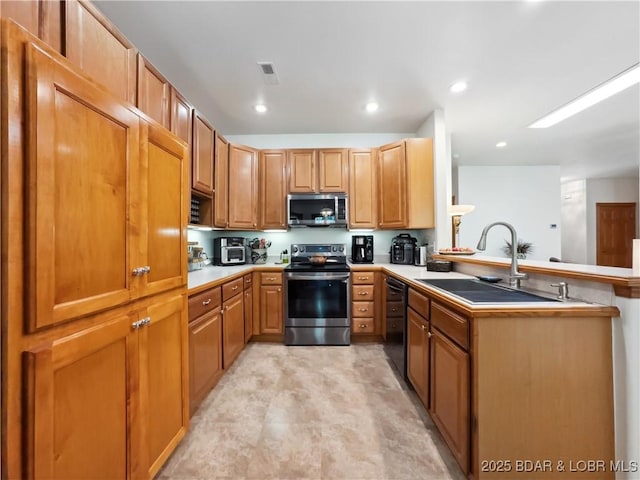204 Wellington Ln, Laurie, MO 65037 - kitchen with appliances with stainless steel finishes, a sink, a peninsula, light countertops, and recessed lighting