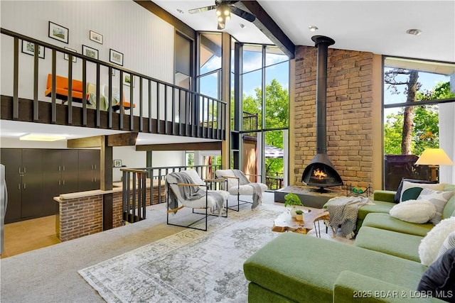 491 Walkers Cay, Osage Beach, MO 65065 - carpeted living room with a wood stove, ceiling fan, a high ceiling, and tile patterned floors