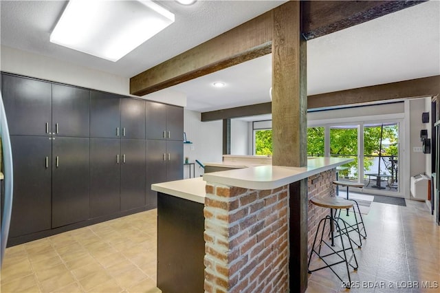 491 Walkers Cay, Osage Beach, MO 65065 - kitchen with a kitchen bar, beam ceiling, light countertops, and a peninsula
