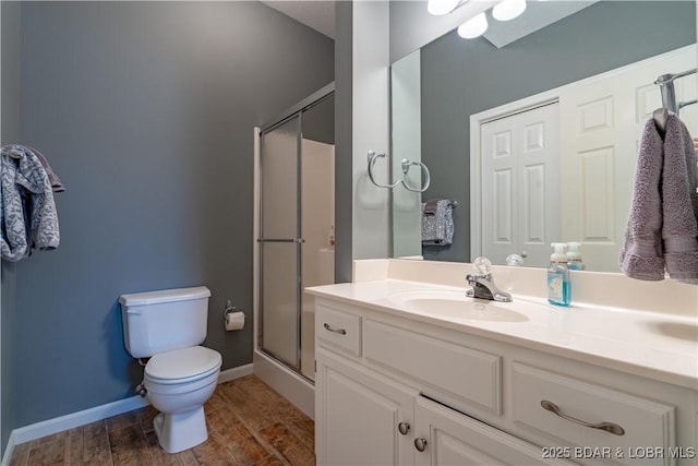 55 Shagbark Dr, Sunrise Beach, MO 65079 - bathroom featuring vanity, a shower stall, toilet, wood finished floors, and baseboards