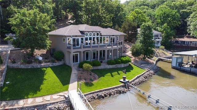 55 Shagbark Dr, Sunrise Beach, MO 65079 - rear view of house with a water view, a lawn, stucco siding, and a wooded view