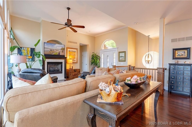 55 Shagbark Dr, Sunrise Beach, MO 65079 - living area with dark wood-type flooring, crown molding, a ceiling fan, a high ceiling, and a chandelier