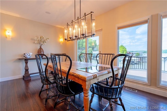 55 Shagbark Dr, Sunrise Beach, MO 65079 - dining area with baseboards, dark wood-type flooring, and a chandelier