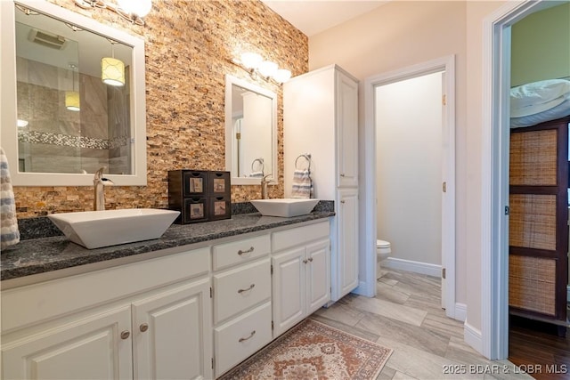 55 Shagbark Dr, Sunrise Beach, MO 65079 - bathroom featuring double vanity, a stall shower, toilet, and baseboards