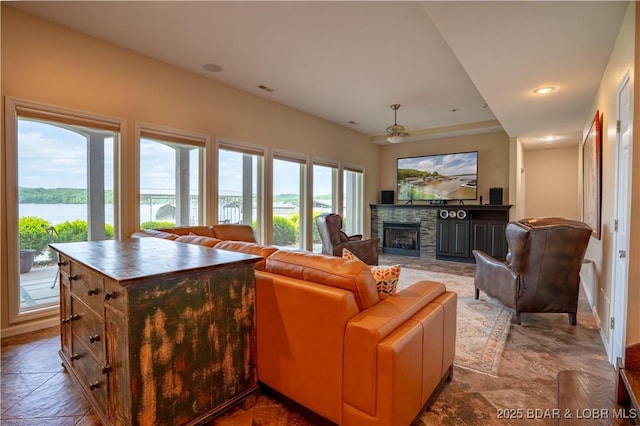 55 Shagbark Dr, Sunrise Beach, MO 65079 - living room featuring a stone fireplace, ceiling fan, stone finish flooring, recessed lighting, and a water view