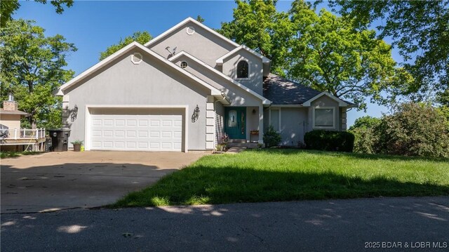 1396 Robyn Ct, Osage Beach, MO 65065 - view of front of home featuring an attached garage, concrete driveway, stucco siding, and a front yard