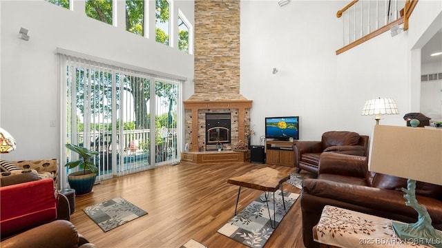 1396 Robyn Ct, Osage Beach, MO 65065 - living area with a high ceiling, wood finished floors, and a stone fireplace