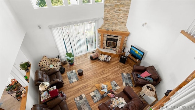 1396 Robyn Ct, Osage Beach, MO 65065 - living room with a towering ceiling, a stone fireplace, wood finished floors, and stairway