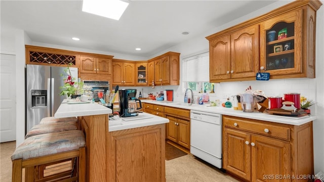 1396 Robyn Ct, Osage Beach, MO 65065 - kitchen with appliances with stainless steel finishes, brown cabinets, glass insert cabinets, a kitchen island, and recessed lighting
