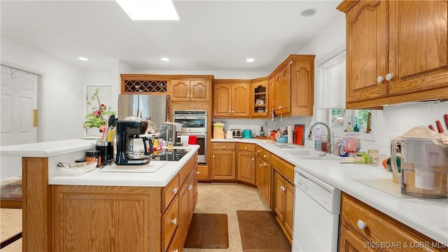 1396 Robyn Ct, Osage Beach, MO 65065 - kitchen with stainless steel appliances, a sink, brown cabinets, a kitchen island, and tasteful backsplash