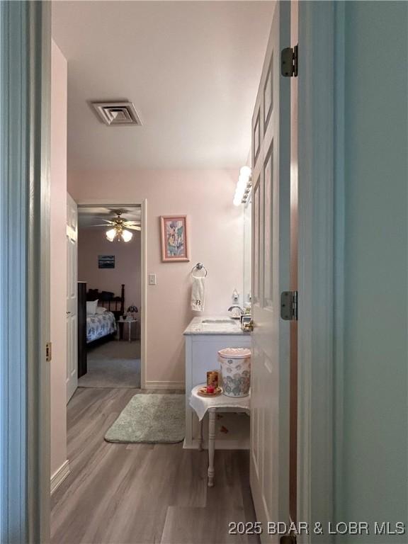 1396 Robyn Ct, Osage Beach, MO 65065 - ensuite bathroom featuring vanity, wood finished floors, baseboards, and ceiling fan