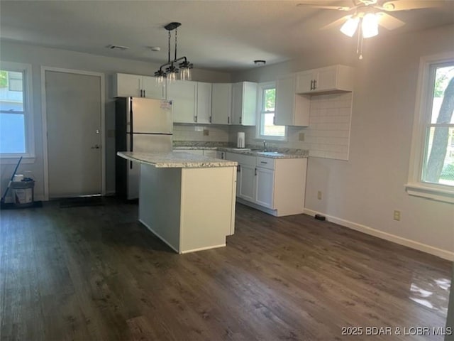 34443 Ivy Bend Rd, Stover, MO 65078 - kitchen with freestanding refrigerator, white cabinetry, and baseboards