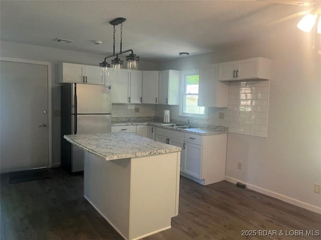 34443 Ivy Bend Rd, Stover, MO 65078 - kitchen featuring freestanding refrigerator, white cabinetry, tasteful backsplash, and baseboards