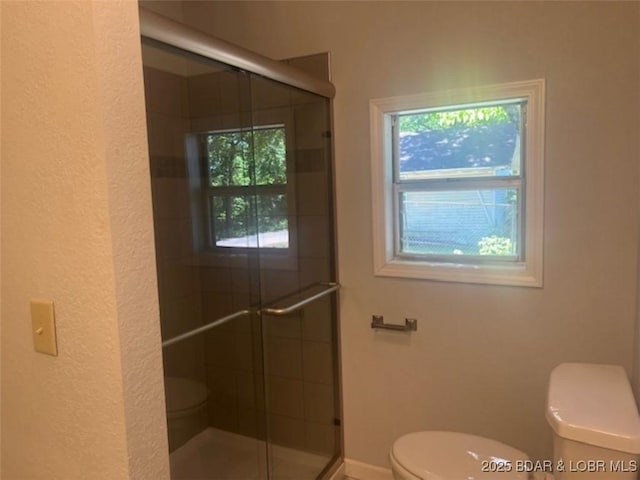 34443 Ivy Bend Rd, Stover, MO 65078 - bathroom featuring toilet, a shower stall, a textured wall, and baseboards