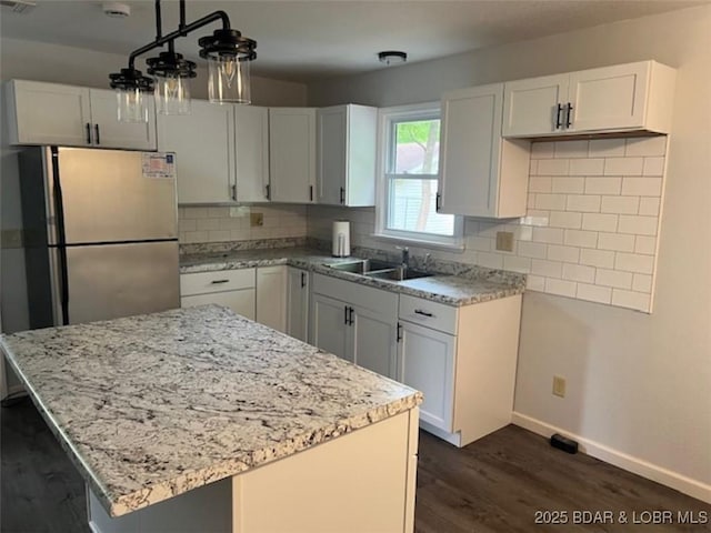 34443 Ivy Bend Rd, Stover, MO 65078 - kitchen featuring freestanding refrigerator, a sink, light stone counters, baseboards, and tasteful backsplash