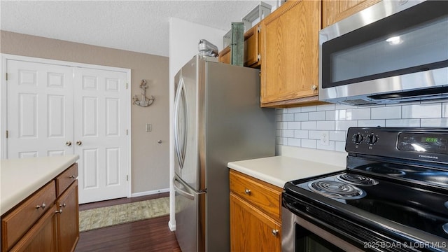 312 Windsor Bay Dr Unit 2A, Camdenton, MO 65020 - kitchen featuring appliances with stainless steel finishes, dark wood finished floors, decorative backsplash, light countertops, and brown cabinetry