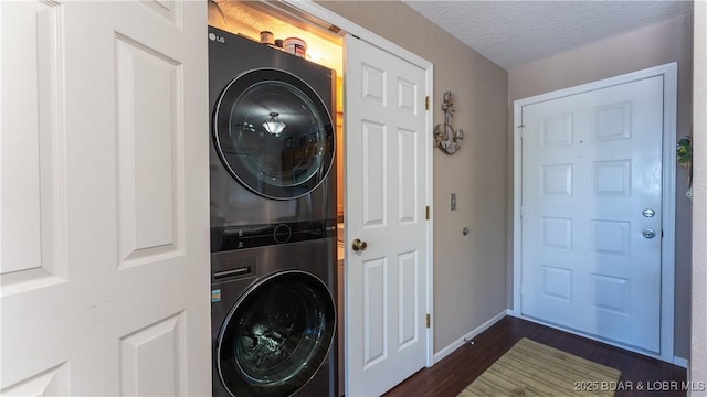 312 Windsor Bay Dr Unit 2A, Camdenton, MO 65020 - washroom featuring stacked washing machine and dryer, dark wood-style floors, a textured ceiling, and baseboards