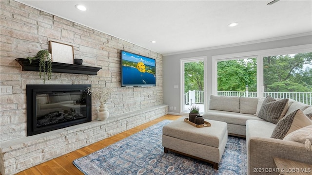 288 Oak Ridge Rd, Lake Ozark, MO 65049 - living area featuring ornamental molding, wood finished floors, a stone fireplace, recessed lighting, and baseboards
