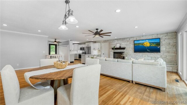 288 Oak Ridge Rd, Lake Ozark, MO 65049 - dining area with ceiling fan, light wood-type flooring, recessed lighting, crown molding, and a fireplace