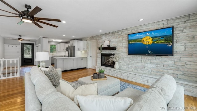 288 Oak Ridge Rd, Lake Ozark, MO 65049 - living room with a ceiling fan, a stone fireplace, light wood-type flooring, and recessed lighting