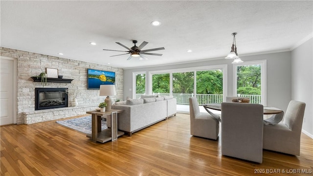 288 Oak Ridge Rd, Lake Ozark, MO 65049 - living area featuring plenty of natural light, wood finished floors, crown molding, ceiling fan, and a stone fireplace
