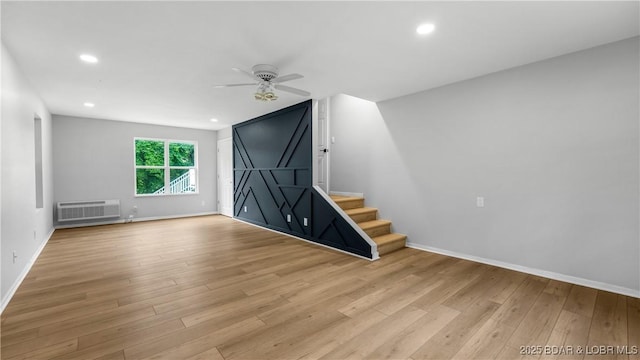 288 Oak Ridge Rd, Lake Ozark, MO 65049 - unfurnished living room with ceiling fan, wood finished floors, stairway, baseboards, and a wall mounted AC