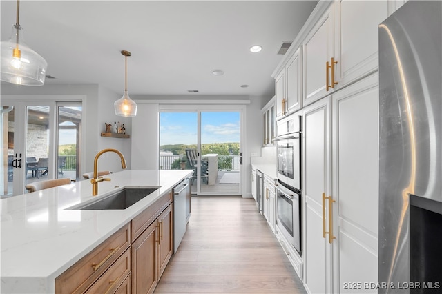 584 Black Hawk Dr, Lake Ozark, MO 65049 - kitchen with stainless steel appliances, a sink, light wood finished floors, recessed lighting, and decorative light fixtures