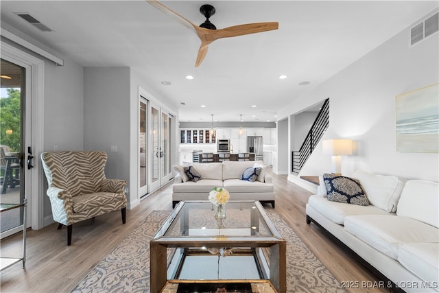 584 Black Hawk Dr, Lake Ozark, MO 65049 - living room featuring a ceiling fan, light wood-style floors, stairway, recessed lighting, and baseboards