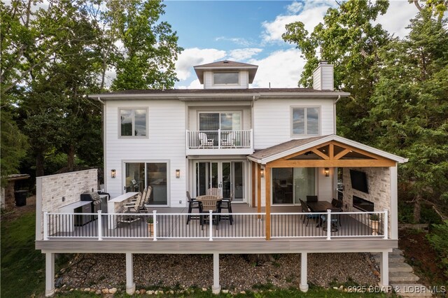 584 Black Hawk Dr, Lake Ozark, MO 65049 - back of property with a chimney, a balcony, and outdoor dining space