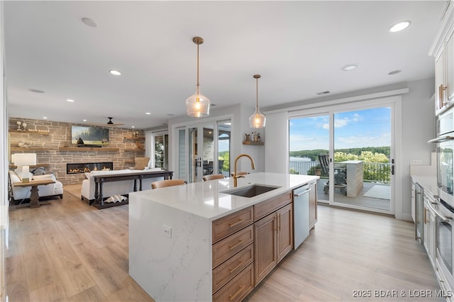 584 Black Hawk Dr, Lake Ozark, MO 65049 - kitchen featuring a sink, stainless steel appliances, light wood-style floors, a fireplace, and recessed lighting