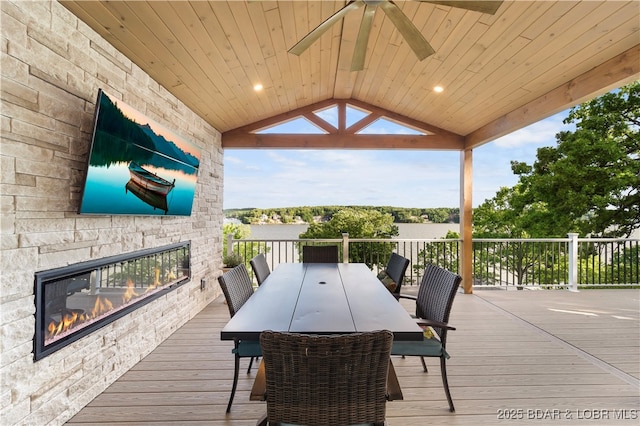 584 Black Hawk Dr, Lake Ozark, MO 65049 - wooden terrace featuring an outdoor stone fireplace, a ceiling fan, and outdoor dining area