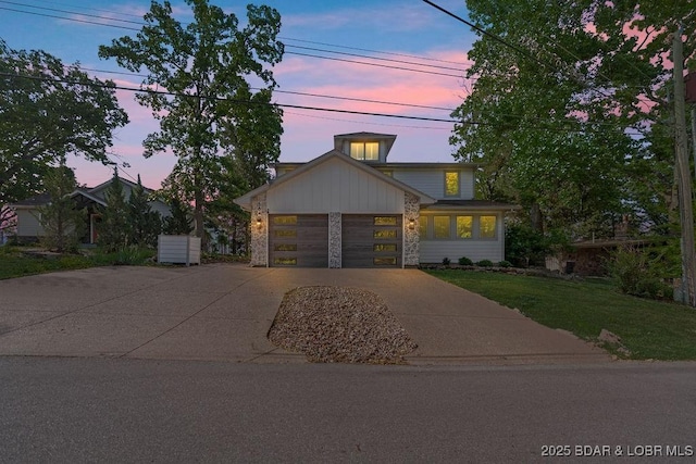 584 Black Hawk Dr, Lake Ozark, MO 65049 - view of front of house featuring concrete driveway, stone siding, a lawn, and an attached garage