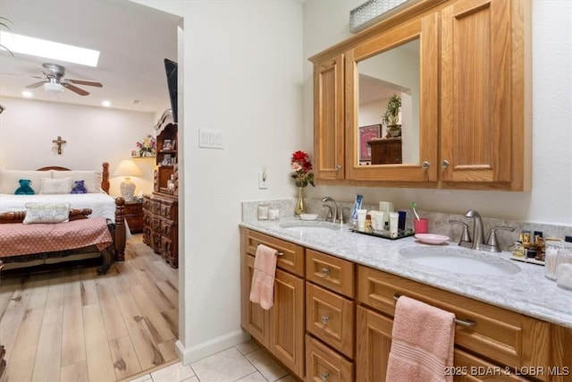 169 Kaanapali Dr, Roach, MO 65787 - ensuite bathroom with double vanity, a ceiling fan, a skylight, and tile patterned floors