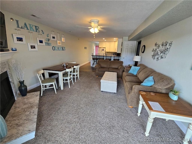 1481 Ledges Dr Unit 221, Osage Beach, MO 65065 - living room featuring a ceiling fan, carpet, a fireplace with flush hearth, and baseboards