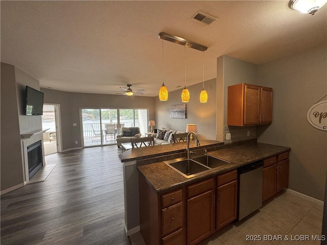 275 Flynn Rd Unit 207, Lake Ozark, MO 65049 - kitchen with dishwasher, dark countertops, a peninsula, open floor plan, and a textured ceiling