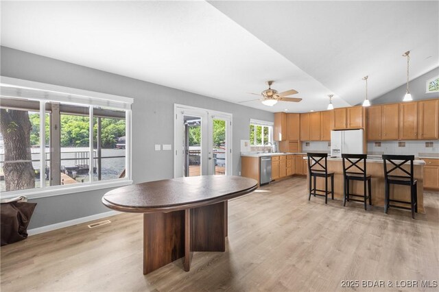 25 Redwood Ct, Sunrise Beach, MO 65079 - kitchen featuring a center island, white fridge with ice dispenser, a sink, light wood-style flooring, and a breakfast bar