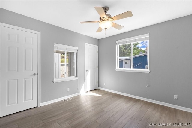 25 Redwood Ct, Sunrise Beach, MO 65079 - unfurnished bedroom with multiple windows, wood finished floors, and baseboards