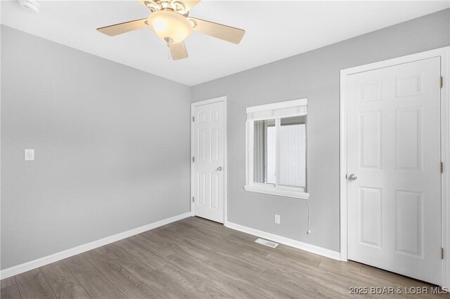 25 Redwood Ct, Sunrise Beach, MO 65079 - unfurnished bedroom with wood finished floors, baseboards, and a ceiling fan