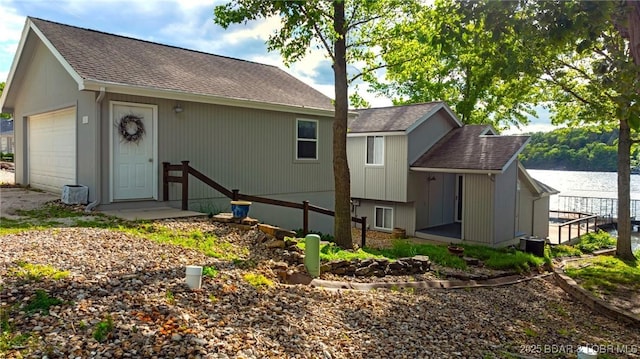 25 Redwood Ct, Sunrise Beach, MO 65079 - back of property featuring roof with shingles, a detached garage, and a water view