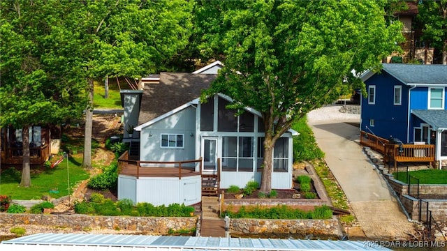 25 Redwood Ct, Sunrise Beach, MO 65079 - view of front of house featuring a sunroom, stairs, a deck, and concrete driveway