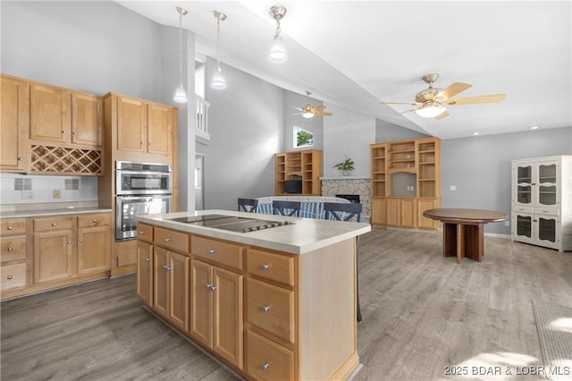 25 Redwood Ct, Sunrise Beach, MO 65079 - kitchen featuring a ceiling fan, light wood-style flooring, black electric stovetop, double oven, and a fireplace